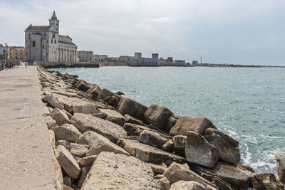 View of buildings by sea against sky