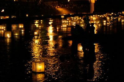 Reflection of illuminated light bulbs in water at night