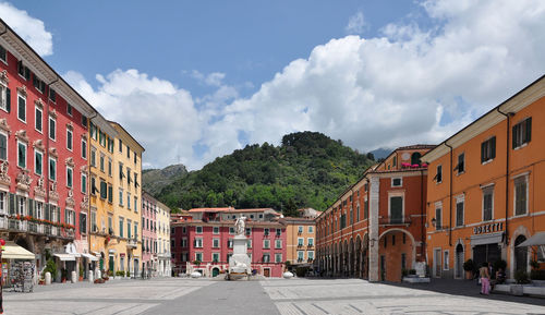 Houses by street in town against sky