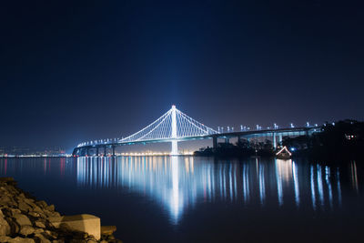 Suspension bridge over river at night