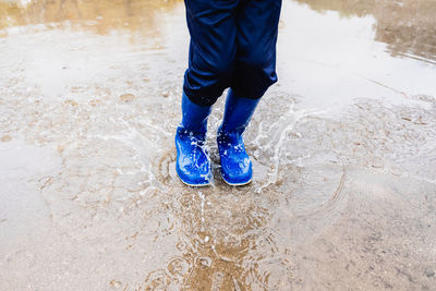 Low section of person standing in water