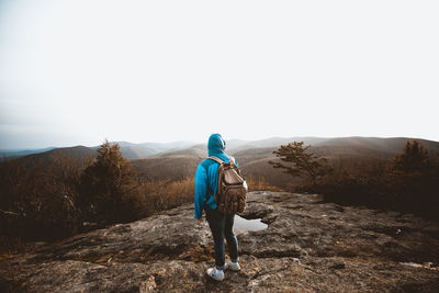 Rear view of man looking at mountain against sky