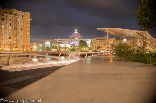 architecture, illuminated, built structure, building exterior, night, city, street light, sky, lighting equipment, the way forward, travel destinations, tree, reflection, tower, modern, tall - high, outdoors, incidental people, street, city life