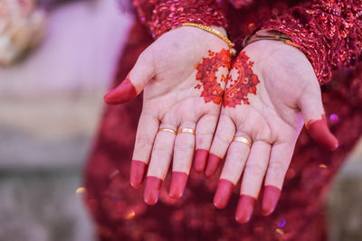 Close-up of woman hand with red leaves