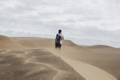 Rear view of man standing on desert