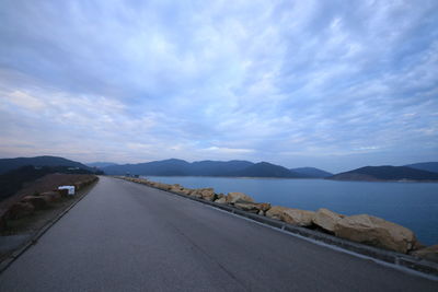 Road by mountain against sky