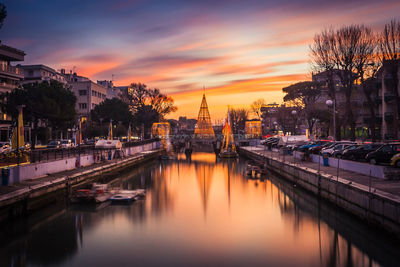 Boats moored at harbor against sky during sunset