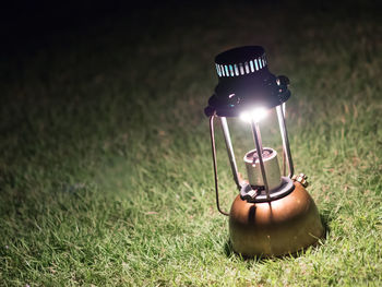 Close-up of illuminated lamp on field