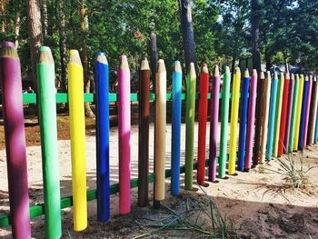 Multi colored umbrellas on field against trees