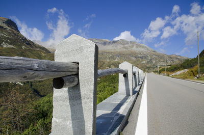 Road by mountains against sky