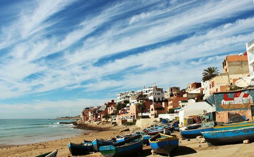 Boats moored at beach against sky