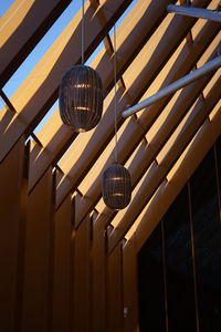 Low angle view of illuminated pendant lights hanging from ceiling