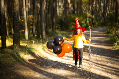 Boy with arms raised in forest