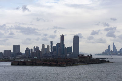 Sea by buildings against sky in city