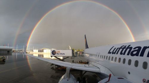 Aerial view of rainbow over airport runway against sky