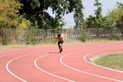 Shirtless man running on track