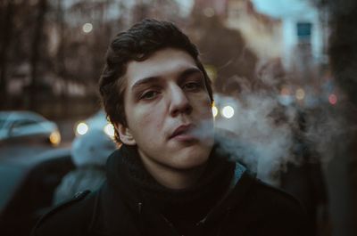 Portrait of man smoking at night