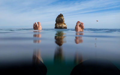 Rock formations in sea against blue sky