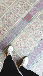 Low section of person standing on tiled floor