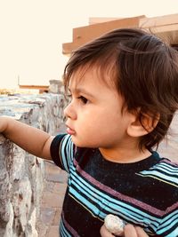 Close-up of cute baby boy standing outdoors