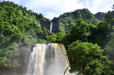 Scenic view of waterfall against sky