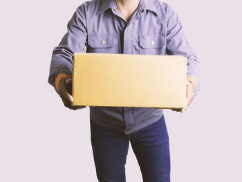 Midsection of man holding paper against white background