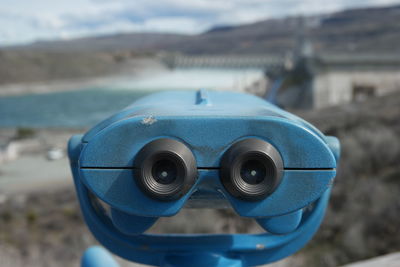 Close-up of coin-operated binoculars against sky