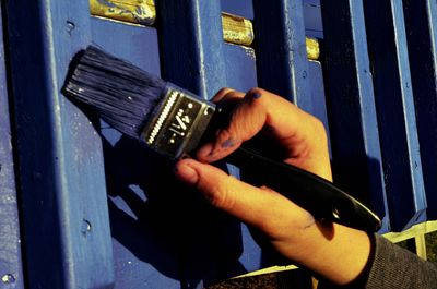 Cropped image of hand painting fence