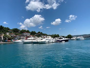 Sailboats moored on sea against sky