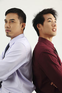 Thoughtful businessmen standing against white background