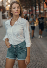 Portrait of young woman standing in city