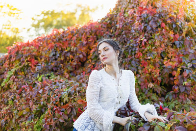 Beautiful brunette with braids around head in vintage white lace long sleeve blouse in an park