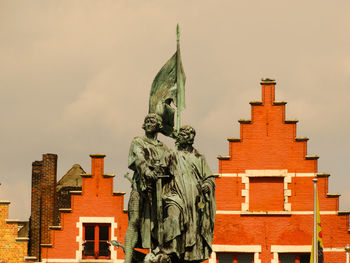 Low angle view of statue of historic building against sky