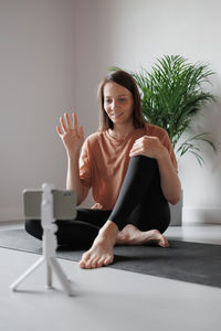 Portrait of young woman sitting on floor at home
