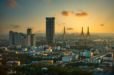 Modern buildings in city against sky during sunset