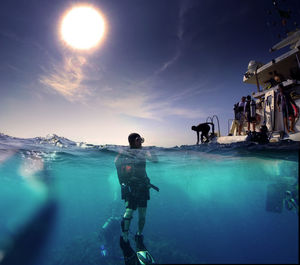 Man scuba diving in red sea against blue sky