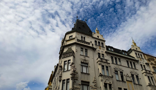 Low angle view of building against cloudy sky