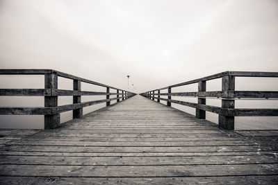 Footbridge over pier against sky