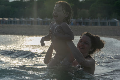 Mother and daughter swimming in sea