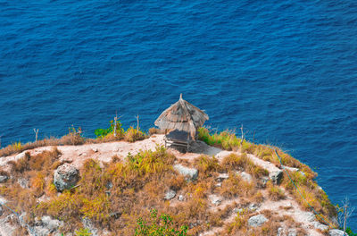 High angle view of rocks by sea against blue sky