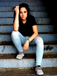 Portrait of young woman sitting on steps