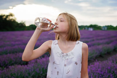 Cute girl drinking water at farm