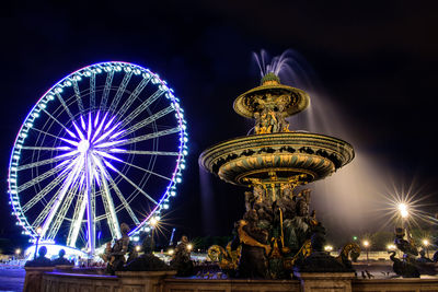 Low angle view of illuminated ferris wheel at night