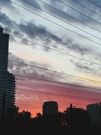 Low angle view of city against sky during sunset