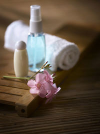 Close-up of pink flowers with beauty products on table