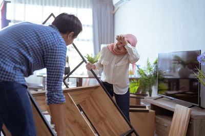 Man and woman arranging furniture at home