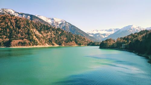 Scenic view of lake by mountains against sky