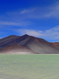 Scenic view of desert against blue sky