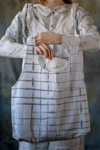 Midsection of woman holding umbrella standing outdoors