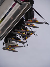 Low angle view of skiers sitting on ski lift